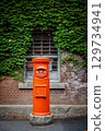 Red mailbox, bricks and green vines 129734941