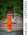 Red mailbox, bricks and green vines 129734942