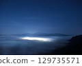 Night view of Mount Aso's sea of clouds and city lights from below 129735571