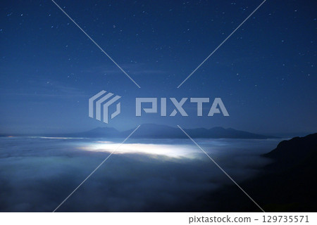 從下方欣賞阿蘇山的雲海和城市燈光的夜景 129735571