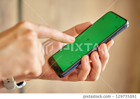 Hands using smartphone with green screen 129735891