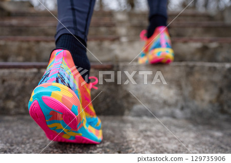 Person wearing running shoes walking up stone steps 129735906
