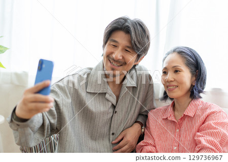 Men and women taking pictures 129736967