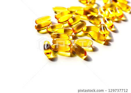 Golden fish oil capsules on white background. Golden fish oil capsules on white background. 129737712