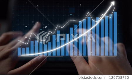 Hands on a Keyboard Analyzing a Financial Graph with Rising Trends and Data Points on a Digital Screen Representing Market Growth and Success Copula 129738720
