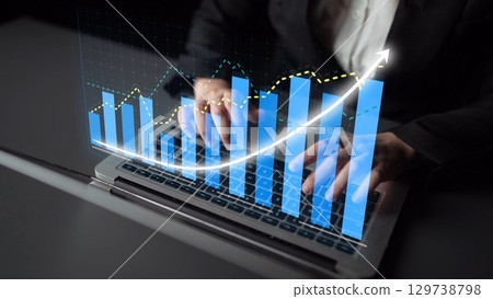 Business Professional Analyzing Data Trends with Laptop in Modern Office Environment Using Graphs and Charts for Financial Growth and Planning Copula 129738798