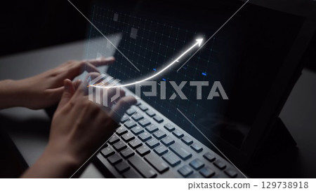 Hands Typing on Laptop with Digital Graph Representing Business Growth and Financial Success Emerging from Screen in Modern Office Setting Copula 129738918