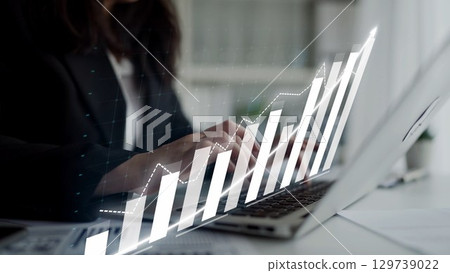 Businesswoman Using Laptop with Financial Graph Overlay in Modern Office Setting for Professional Growth and Investment Planning Copula 129739022