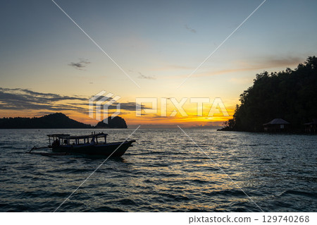 Boat at sunset on Bolilanga Island, Togian archipelago, Sulawesi, Indonesia 129740268