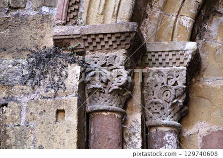 Columns of Abbey Church of Sainte-Foy in Conques, France, intricate stone carvings 129740608