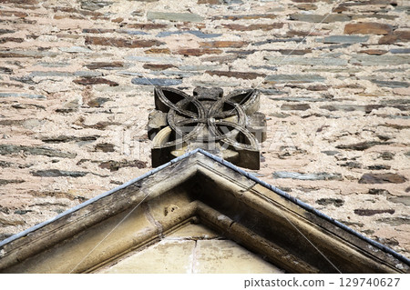 Roof gable stone carving detail on Abbey Church of Sainte-Foy in Conques, France 129740627