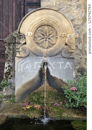 Historic stone fountain in Beynac-et-Cazenac village, France 129740764