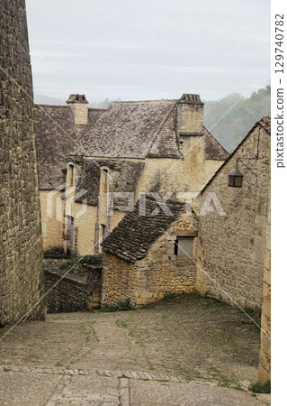 Stone houses nestled along a quiet pathway in Beynac-et-Cazenac village, France Stone houses nestled along a quiet pathway in Beynac-et-Cazenac village, France 129740782