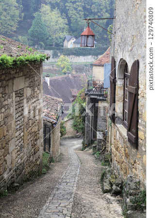 Charming cobblestone path leading to a historic house in Beynac-et-Cazenac, France under overcast skies Charming cobblestone path leading to a historic house in Beynac-et-Cazenac, France under overcast skies 129740809