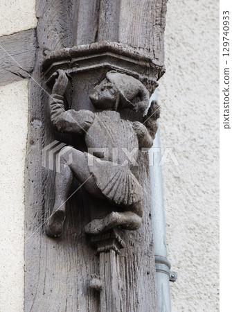 Sculpted wooden figure clinging to a pillar in historic Blois, France 129740933