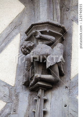 Sculpted wooden figure clinging to a pillar in historic Blois, France 129740935
