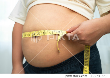 Asian woman with fat belly big size overweight and obesity with measure tape. 129741330