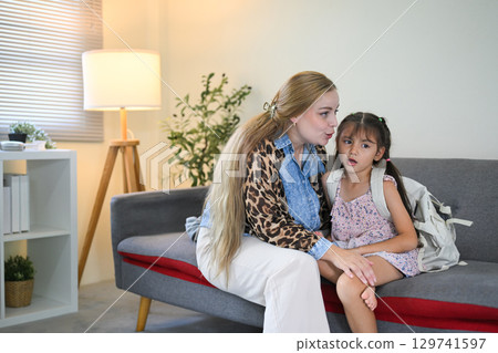 Mother comforting her daughter who looks upset and reluctant to go to school 129741597
