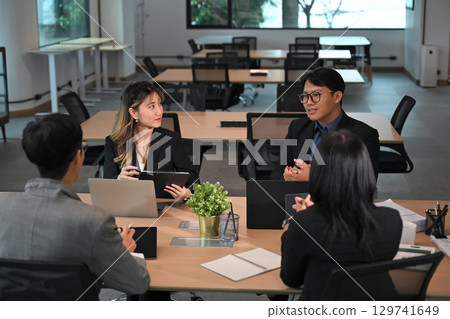 Professional colleagues discussing project details in a modern office Professional colleagues discussing project details in a modern office 129741649