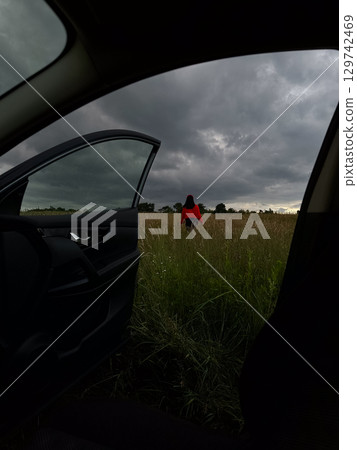 Person in Red Jacket Standing in Field 129742469