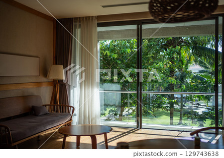 stylish apartment interior with tropical window view, modern elegance and serene nature, chic home decor featuring exotic greenery, luxurious calm and vibrant design 129743638