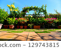 Enjoy your apartment roof balcony with blue skies, plants, and tiles 129743815