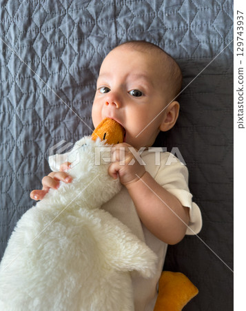 Baby Smiling with Plush Duck Toy Baby Smiling with Plush Duck Toy 129743937
