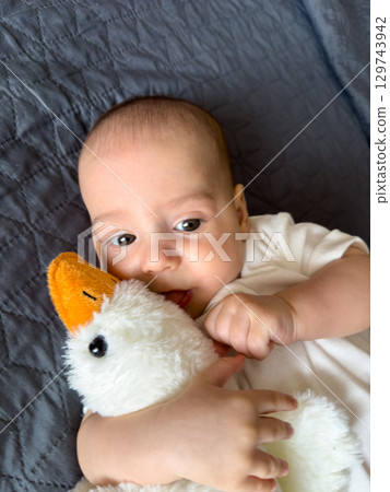 Baby Smiling with Plush Duck Toy 129743942