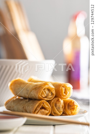 Fried spring rolls on plate on white table. 129744512
