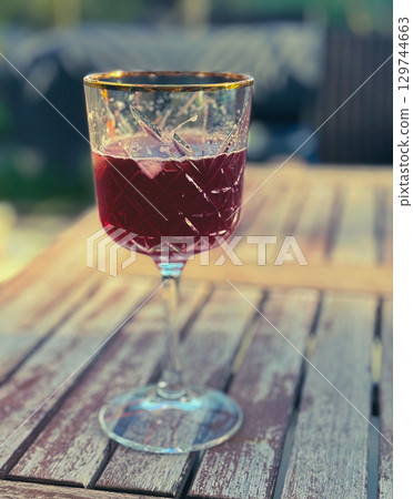 Glass of red wine and grape cluster in the vineyards of France in autumn Glass of red wine and grape cluster in the vineyards of France in autumn 129744663