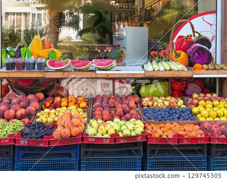 Colorful street stall with fresh fruits and vegetables displayed in neat crates. Concept of fruit market, summer harvest, healthy nutrition, dieting Colorful street stall with fresh fruits and vegetables displayed in neat crates. Concept of fruit market, summer harvest, healthy nutrition, dieting 129745305