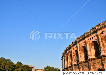 Nimes Amphitheatre at dawn with the moon visible and a clear summer sky (France / Photographed on August 13, 2025) 129745799