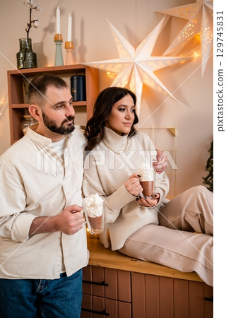 Cozy Couple Enjoying Hot Chocolate in Festive Setting Cozy Couple Enjoying Hot Chocolate in Festive Setting 129745831