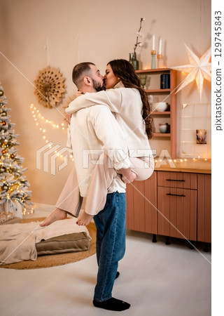 Romantic Embrace with Holiday Decor in Cozy Home 129745843