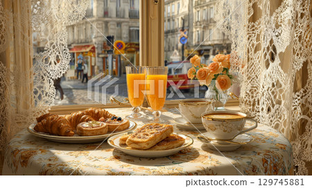Elegant French breakfast with croissants and orange juice on a cozy cafe table by the window, Parisian morning 129745881