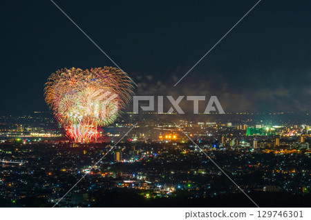 A summer tradition: Fireworks display. Night view of Kumamoto city and the Gozu Lake fireworks display seen from the Aso District viewpoint. 129746301