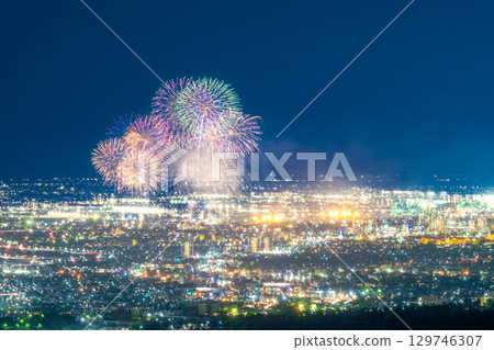 A summer tradition: Fireworks display. Night view of Kumamoto city and the Gozu Lake fireworks display seen from the Aso District viewpoint. 129746307