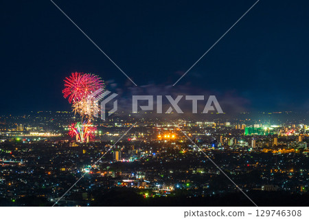A summer tradition: Fireworks display. Night view of Kumamoto city and the Gozu Lake fireworks display seen from the Aso District viewpoint. 129746308