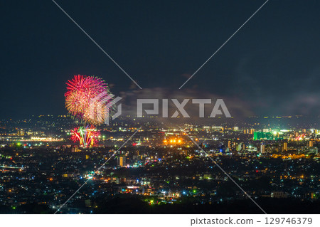 A summer tradition: Fireworks display. Night view of Kumamoto city and the Gozu Lake fireworks display seen from the Aso District viewpoint. 129746379