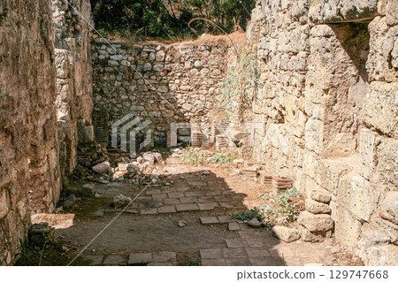 Stone ancient ruins of Phaselis Ancient City in Turkey with stone walls and greenery 129747668