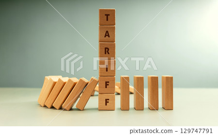 Falling dominoes halted by a vertical stack labeled TARIFF, Trade barriers affect global economies in domino impact Falling dominoes halted by a vertical stack labeled TARIFF, Trade barriers affect global economies in domino impact 129747791
