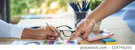 Banner Two businesspeople meeting work at office desk. Teamwork partners team with Business strategy chart graph, infographic financial report. Team partner planning excel stat report with copy space 129748203