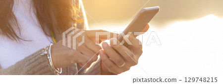 Banner Woman hands holding mobile phone outdoor surfing internet online technology lifestyle. Close up woman hand using smartphone gadget text message panoramic with copy space. Technology lifestyle Banner Woman hands holding mobile phone outdoor surfing internet online technology lifestyle. Close up woman hand using smartphone gadget text message panoramic with copy space. Technology lifestyle 129748215