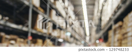 Blurred Background Commercial packaging on steel rack. Aisle in storehouse inventory. Warehouse background storage inventory shelf with freight container aisle space. Blur supply lot shelf cardboard 129748233