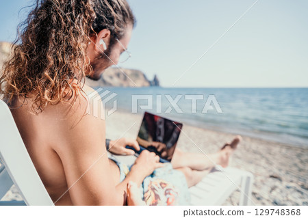 Laptop Beach Work Man using laptop while on beach. Laptop Beach Work Man using laptop while on beach. 129748368