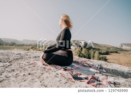 Woman in Black Outfit Sitting on a Rock with a Blanket in a Mountainous Landscape Woman in Black Outfit Sitting on a Rock with a Blanket in a Mountainous Landscape 129748990