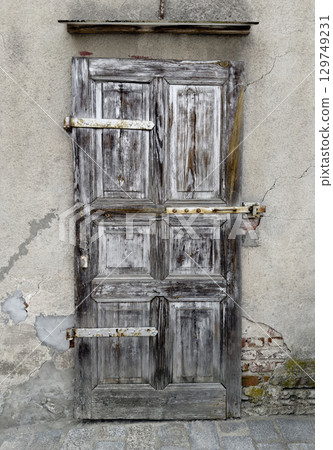 Old damaged wooden entrance door of brick building 129749231