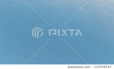 Tranquil blue waters of the Aegean sea gently ripple under the summer sun, creating a serene seascape near Kassandra, Greece 129749547