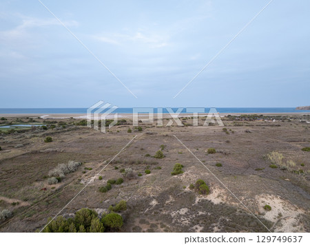Aerial view of Leucate coastline showing dry vegetation and the Mediterranean sea in Occitanie, France Aerial view of Leucate coastline showing dry vegetation and the Mediterranean sea in Occitanie, France 129749637