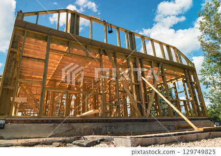 Building a wooden frame house under construction on a sunny day 129749825